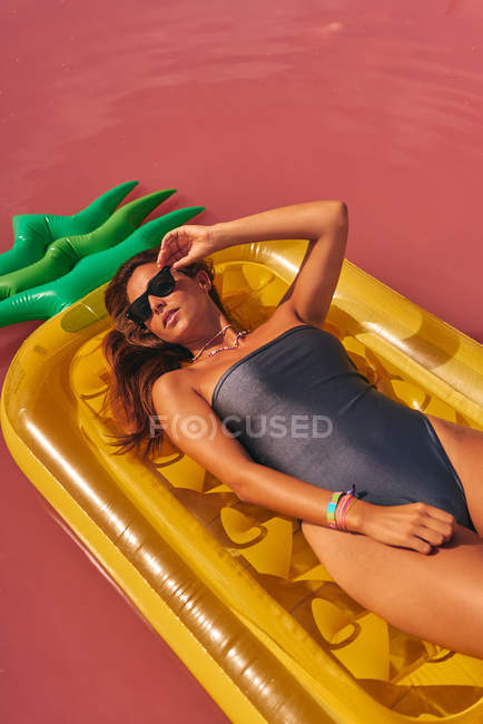 Femme rêveuse reposant sur un matelas gonflable — Photo de stock
