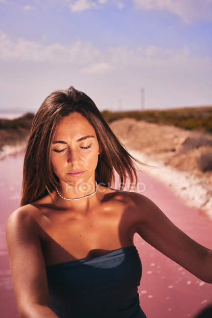 Mujer joven bronceada en traje de baño a la luz del sol - foto de stock