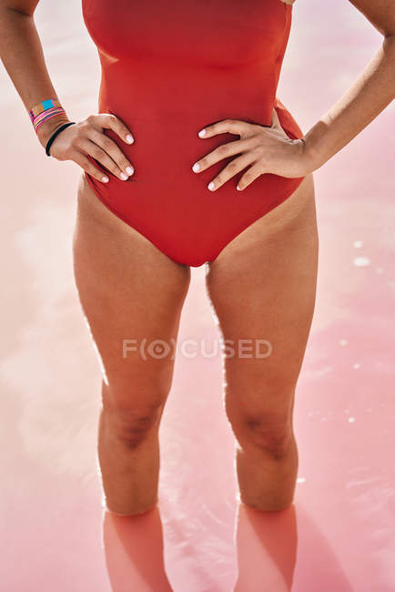 Ausgeschnittene Ansicht einer Frau im roten Badeanzug, die im Wasser posiert — Stockfoto