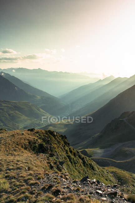 Foggy landscape of amazing mountains in sun light and path between in bright day — Stock Photo