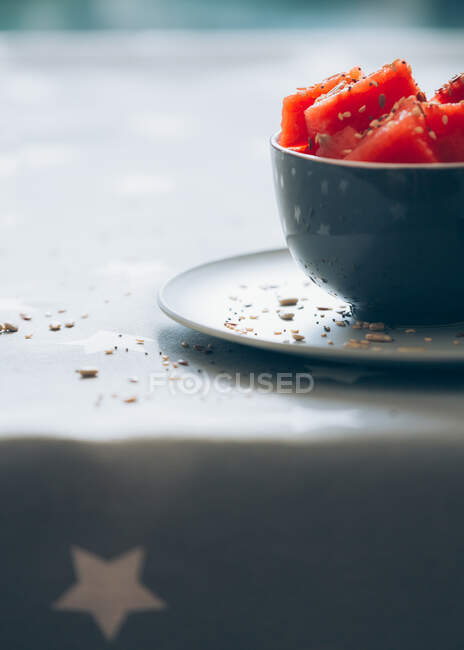 Cut pieces of watermelon in bowl garnished on tablecloth — Stock Photo