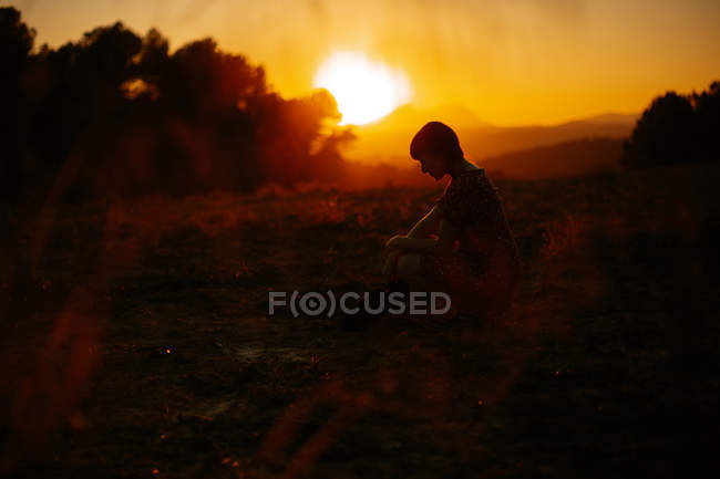 Vista lateral da mulher sensual com olhos fechados no meio de um prado com sol ao pôr do sol à noite no campo — Fotografia de Stock