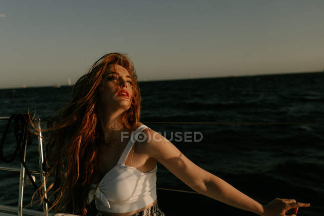 Attraente e attraente rossa donna guardando lontano mentre si viaggia sulla nave — Foto stock