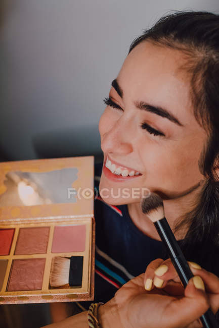 Une belle jeune femme se fait maquiller par un maquilleur professionnel en salon — Photo de stock