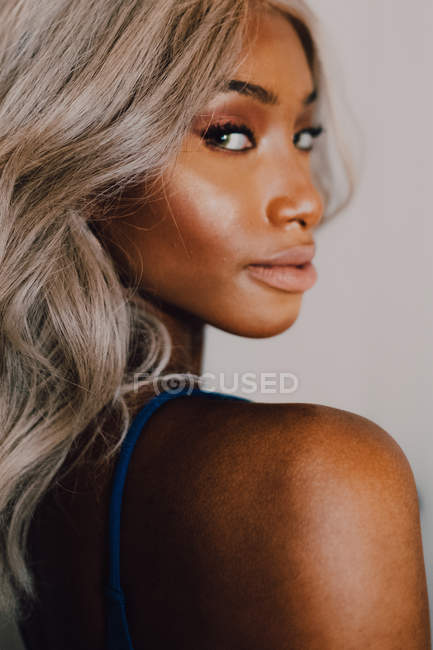 Portrait of adult African American woman with blond hair wearing blue and looking at camera — Stock Photo