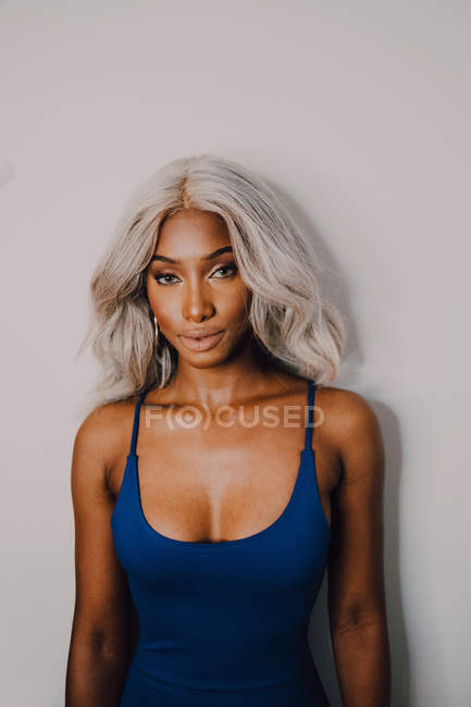 Porträt einer erwachsenen Afroamerikanerin mit blonden Haaren, die blau trägt und in die Kamera blickt — Stockfoto