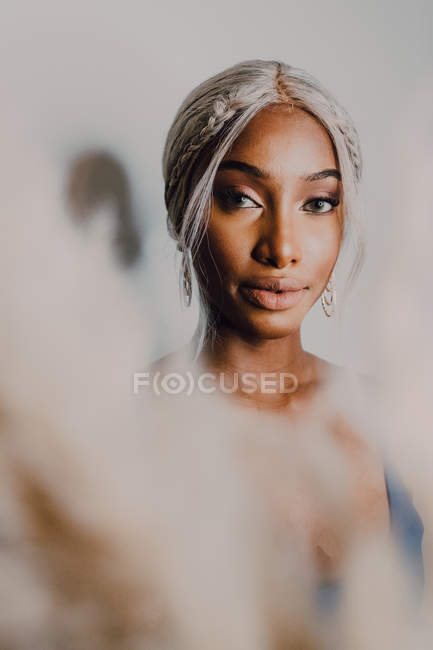 Porträt einer erwachsenen Afroamerikanerin mit blonden Haaren, die blau trägt und in die Kamera blickt — Stockfoto