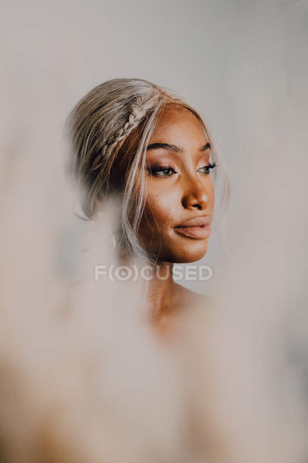 Retrato de mulher americana africana adulta com cabelos loiros vestindo azul e olhando para longe — Fotografia de Stock
