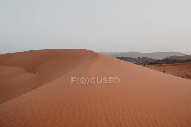Hügel aus trockenem Sand inmitten einer großen Wüste gegen grauen Himmel in Marokko — Stockfoto