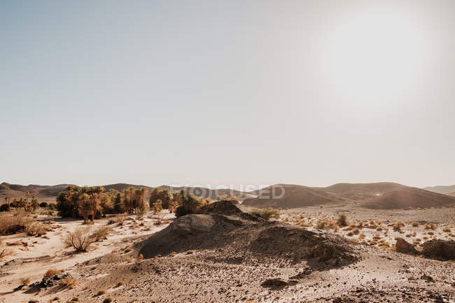 Cloudy sundown sky over hills and rocks in arid desert in evening in Morocco — Stock Photo