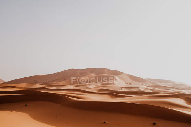 Colina de areia seca no meio do deserto grande contra céu cinza em Marrocos — Fotografia de Stock