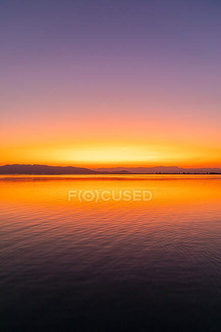 Couleurs intenses d'un coucher de soleil avec des reflets dans l'eau — Photo de stock