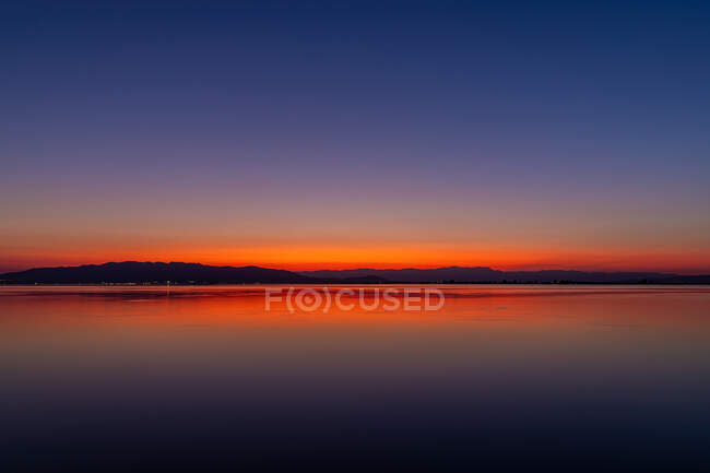 Интенсивные цвета заката с отражениями в воде — стоковое фото