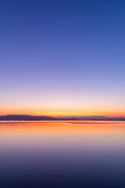 Інтенсивні кольори заходу сонця з відображенням у воді — стокове фото