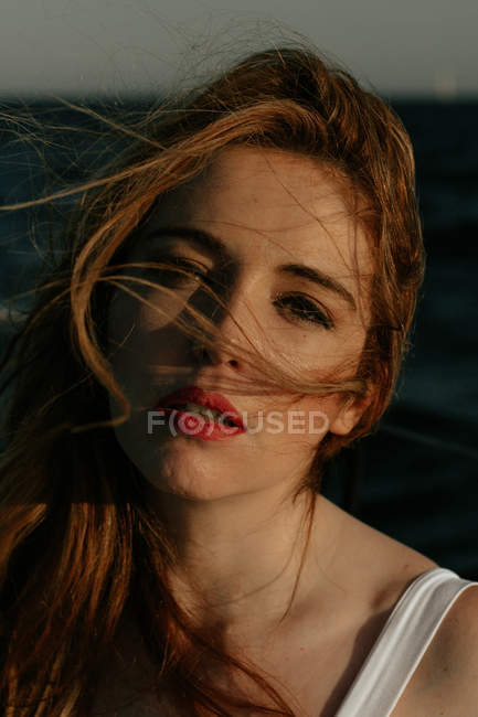 Ansprechende und attraktive rothaarige Dame schaut in die Kamera und genießt die Schiffsreise — Stockfoto