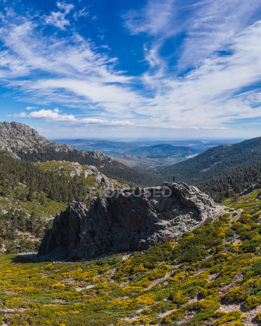 Amazing landscape of stone hills covered by dry grass under big fluffy white clouds on sky — Stock Photo