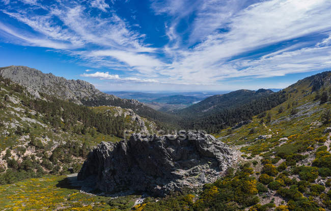 Amazing landscape of stone hills covered by dry grass under big fluffy white clouds on sky — Stock Photo
