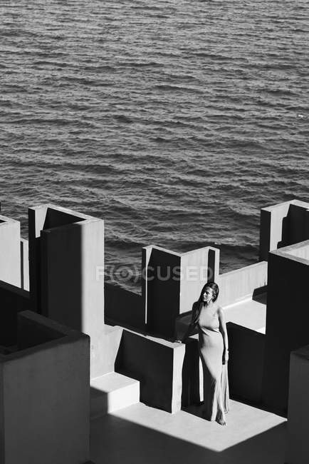 Woman in dress standing on roof of building — Stock Photo