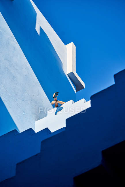 Cropped image of woman on top of building holding smartphone — Stock Photo