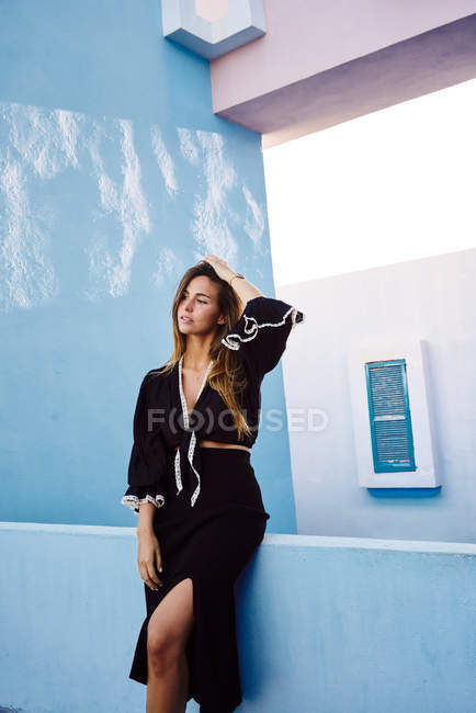 Mulher em pé no edifício azul moderno e olhando para longe — Fotografia de Stock