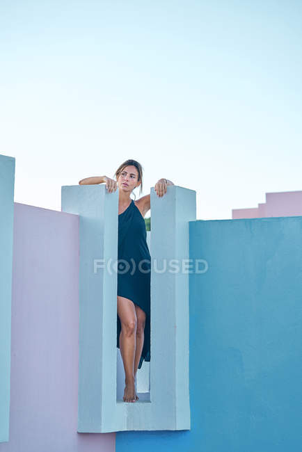 Mulher de pé no topo do edifício azul e olhando para longe — Fotografia de Stock