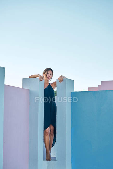 Mulher de pé no topo do edifício azul e olhando para a câmera — Fotografia de Stock