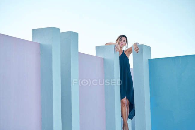 Жінка стоїть на вершині синьої будівлі і дивиться на камеру — стокове фото