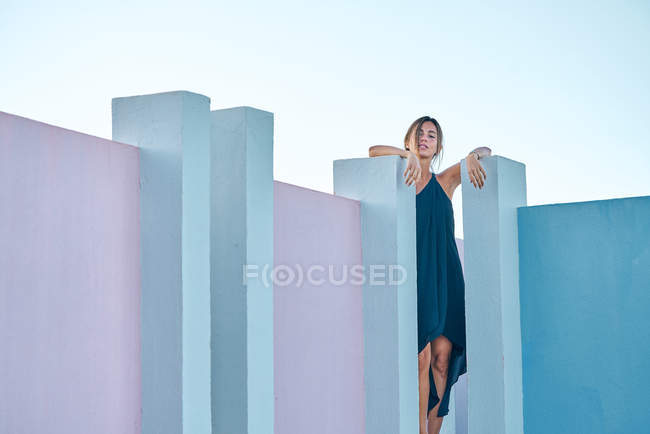 Frau steht auf blauem Gebäude und blickt in Kamera — Stockfoto