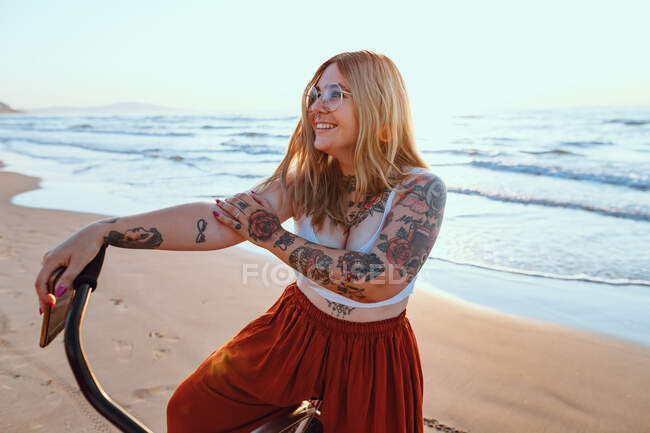 Fröhliche Frau radelt am friedlichen Strand entlang — Stockfoto