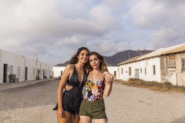 Прихильна пара жінок, що ходить по старому місту, приймає і дивиться на камеру — стокове фото