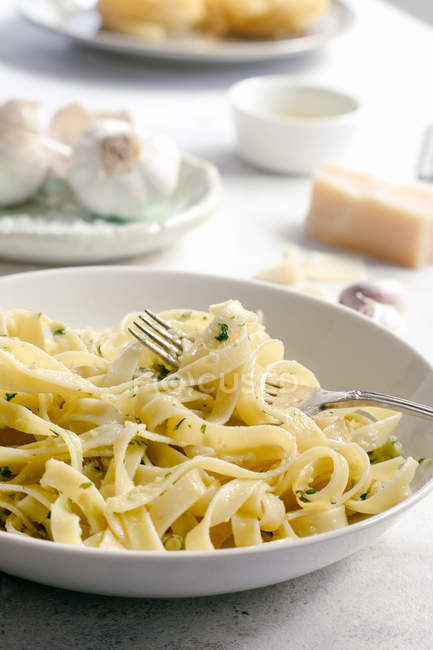 Cooked tagliatelle pasta with pesto sauce on fork — Stock Photo