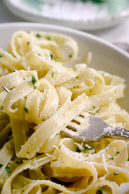Cooked tagliatelle pasta with pesto sauce on fork — Stock Photo
