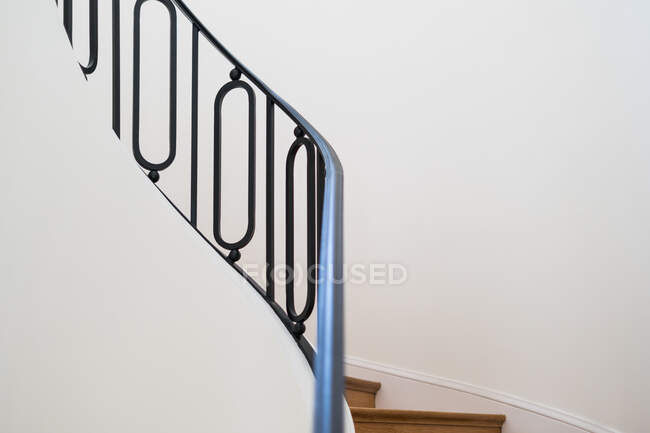 Solid wooden staircase with black railing in house with light interior - foto de stock