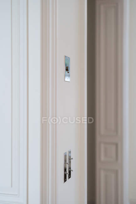 Interrupteur en métal sur mur blanc dans la chambre avec intérieur minimaliste à la mode — Photo de stock