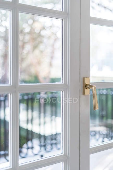 Closed light house balcony doorway with modern golden handle in soft light — Stock Photo