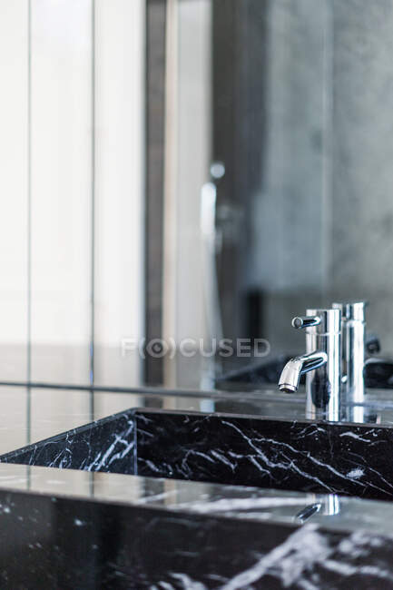 Lavabo rectangulaire et robinet en acier brillant dans la salle de bain luxueuse à la lumière du jour — Photo de stock