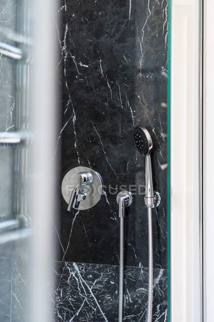 Chrome shiny shower tap and holder in marble cabin in luxury house - foto de stock