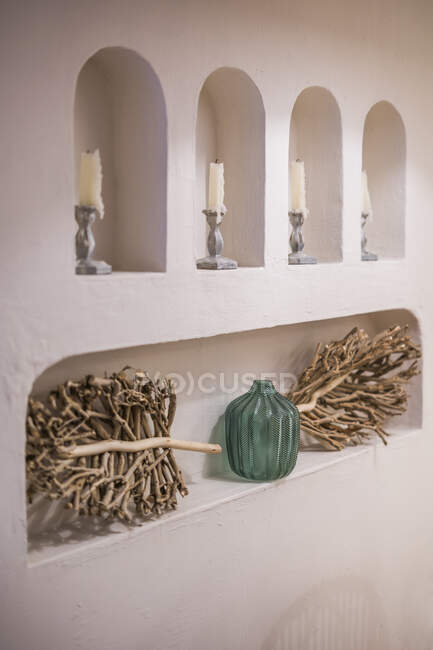 White wall niche with candlesticks and ornamental dried sticks decor — Stock Photo
