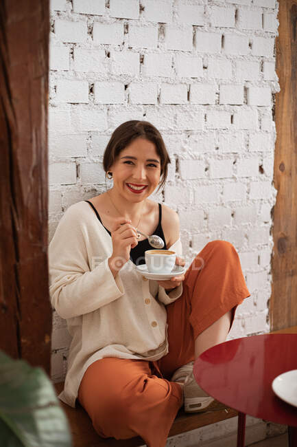 Peaceful woman drinking coffee while resting at home — Stock Photo