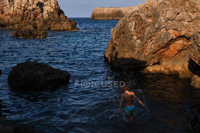 Active kid in diving mask standing in sea water — Stock Photo
