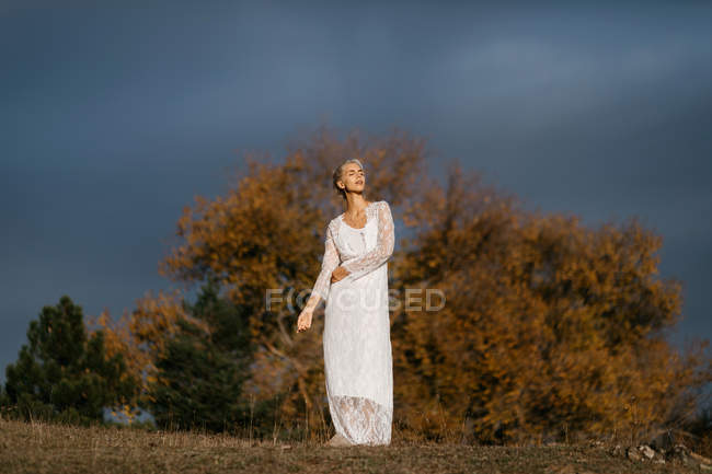 Schöne blonde Frau blickt auf die herbstliche Landschaft — Stockfoto