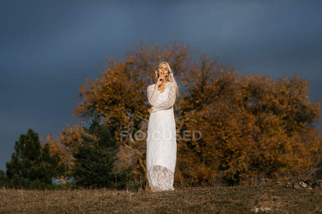 Красива блондинка дивиться на осінню сільську місцевість — стокове фото