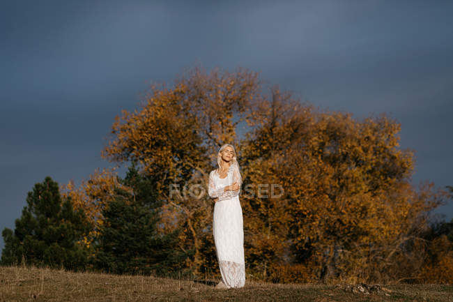 Schöne blonde Frau blickt auf die herbstliche Landschaft — Stockfoto