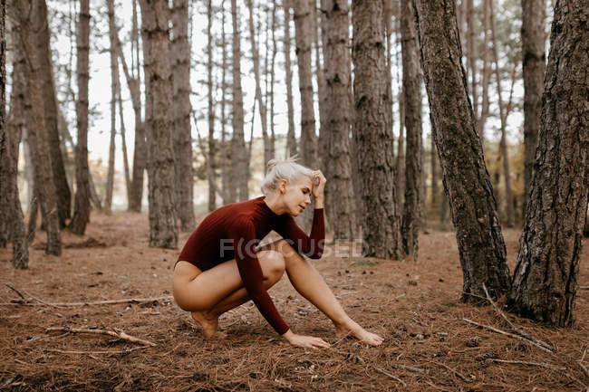 Beautiful woman resting barefoot in evergreen forest — Stock Photo