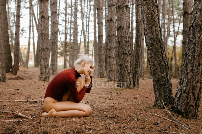 Belle femme moderne reposant pieds nus dans la forêt à feuilles persistantes — Photo de stock