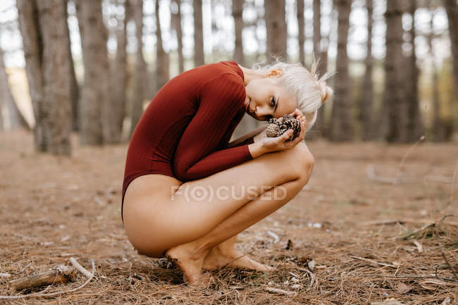 Belle femme moderne reposant pieds nus dans la forêt à feuilles persistantes — Photo de stock