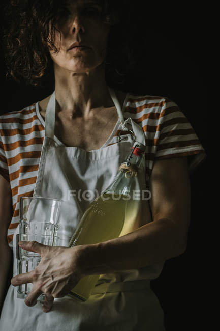 Mujer sosteniendo botella de vino de saúco y dos copas - foto de stock