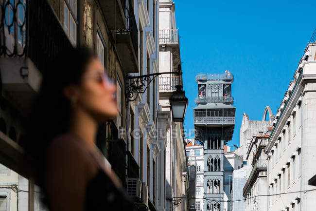 Verschwommene Frau auf malerischer sonniger Stadtstraße in der Nähe von Santa Justa Lift in Lissabon, Portugal — Stockfoto