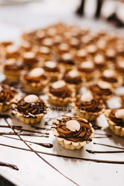 Ensemble de pâtisseries mielleuses avec crème au caramel sucrée et noix disposées sur du papier parchemin — Photo de stock