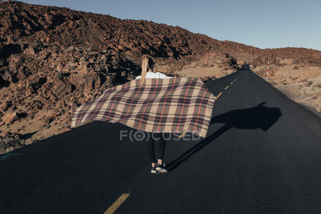 Женщина в клетке идет по пустой дороге — стоковое фото